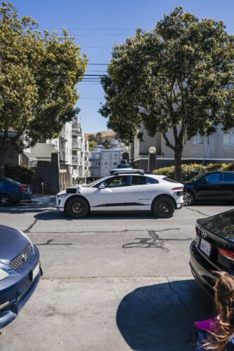 Autonomous car on city street representing the human cost of automation