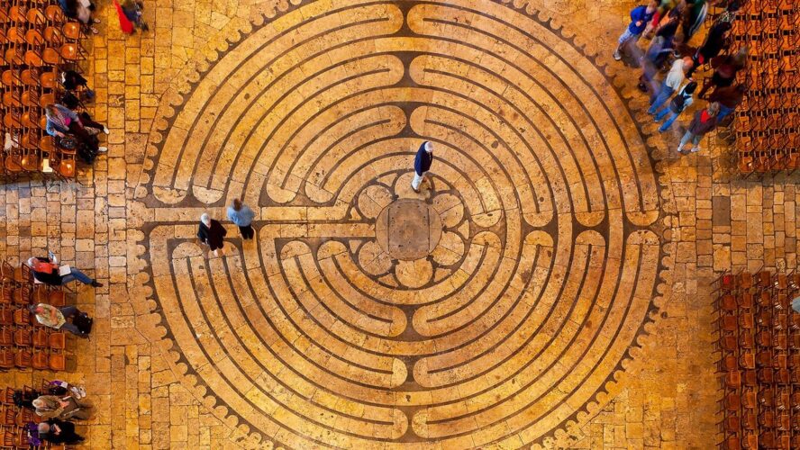 Aerial view of people walking a stone labyrinth - finding your true value hierarchy